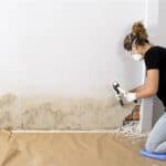 mujer arreglando pared con humedad