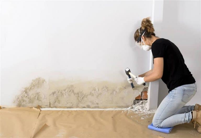 mujer arreglando pared con humedad
