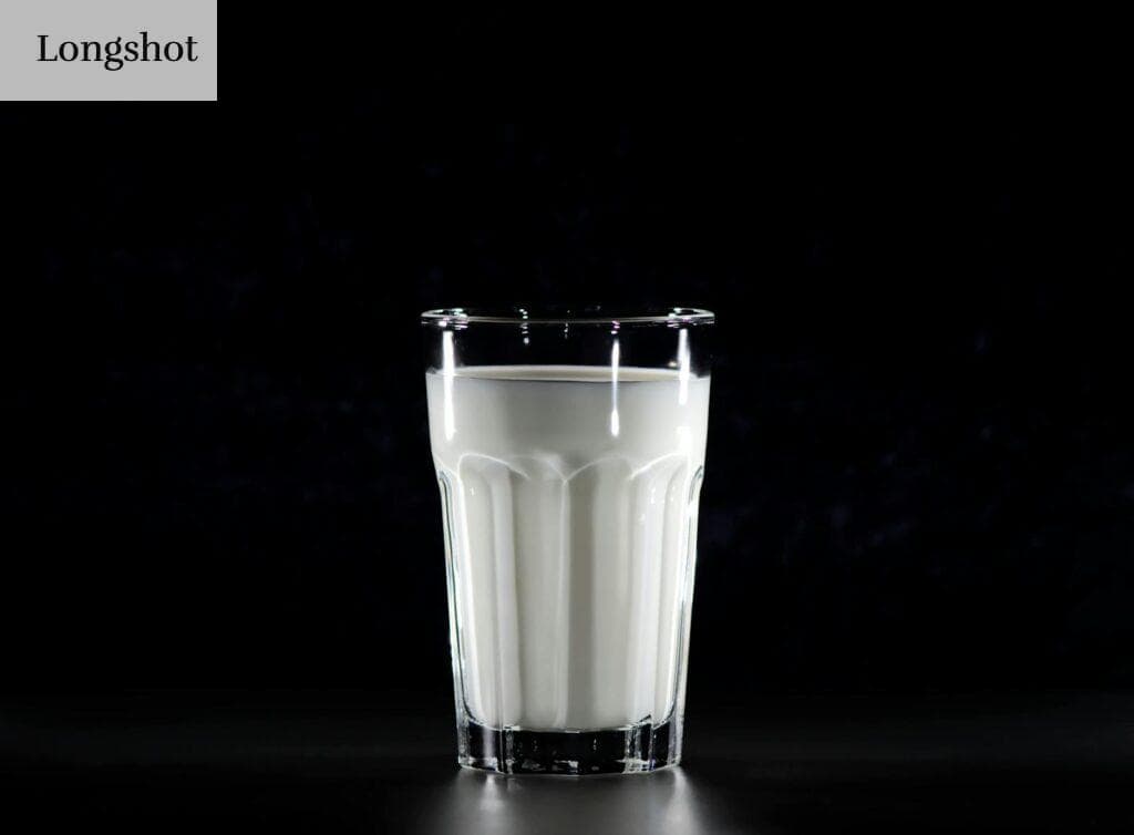 A glass of fresh milk against a black background, emphasizing simplicity and nutrition.