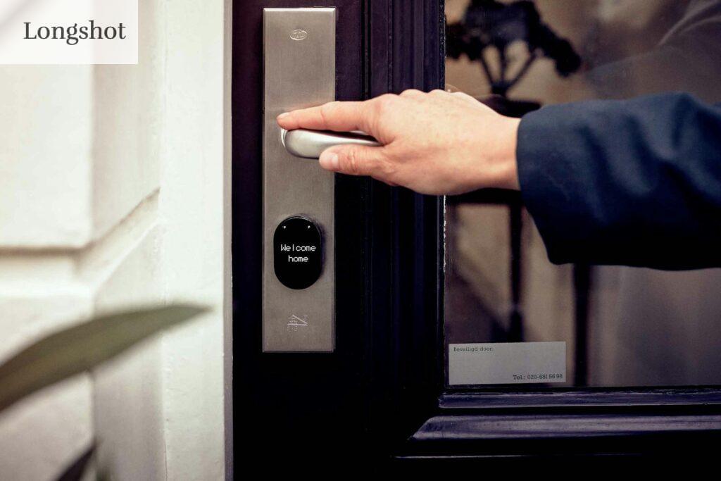 A hand opening a smart home door with digital access panel, conveying security and technology.