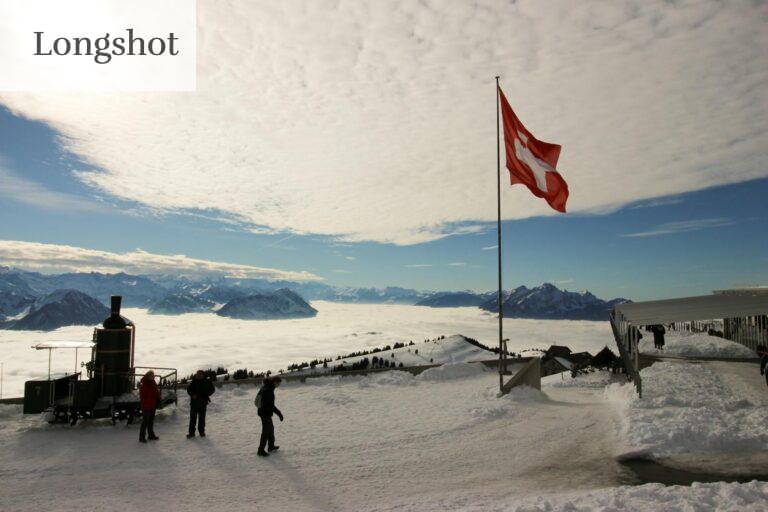Majestic snowy view from Rigi Kulm, Switzerland, with Swiss flag and mountains.
