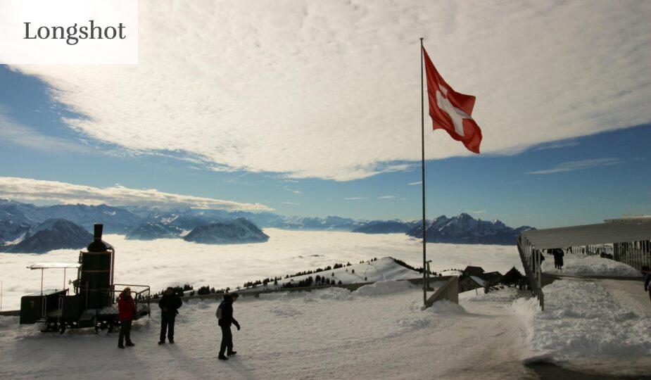 Majestic snowy view from Rigi Kulm, Switzerland, with Swiss flag and mountains.