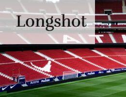 a soccer field with red seats and a green field