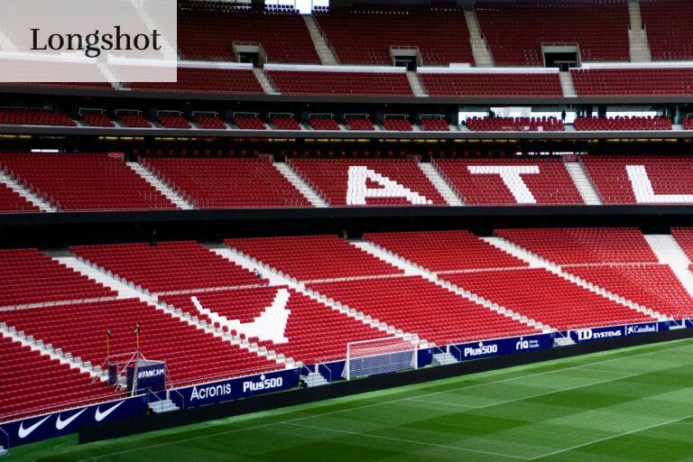 a soccer field with red seats and a green field
