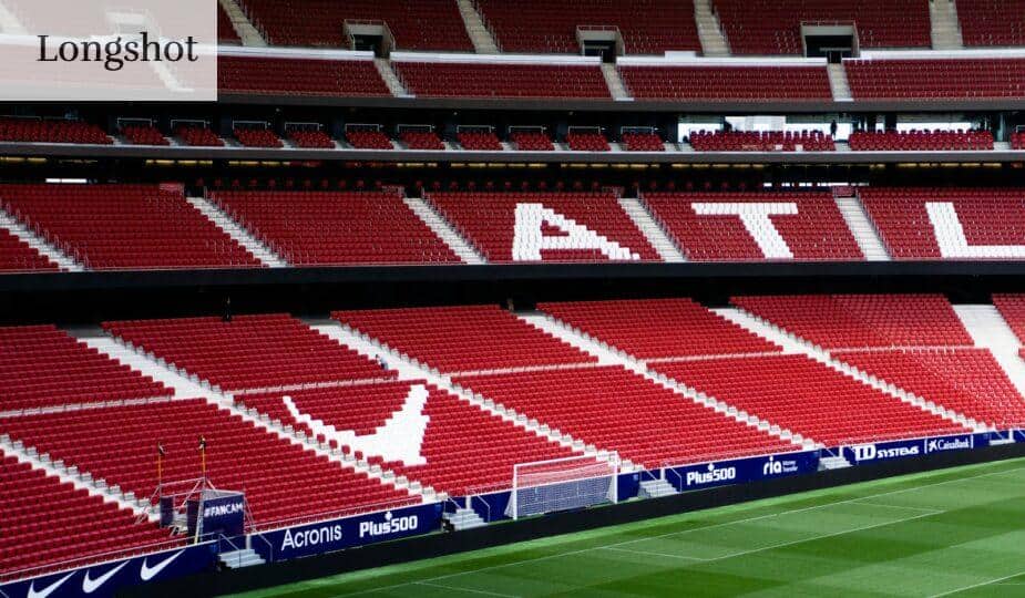 a soccer field with red seats and a green field