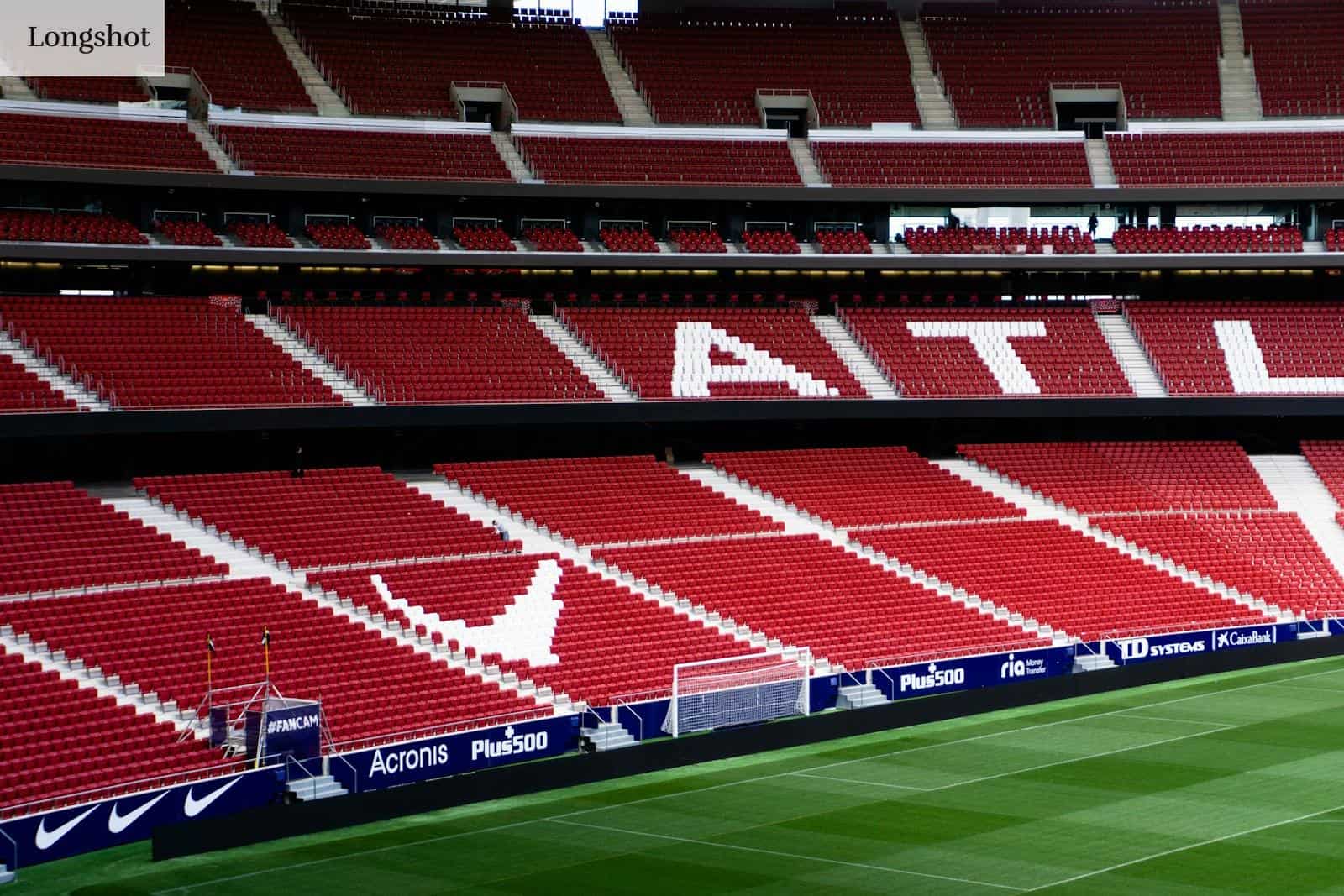 a soccer field with red seats and a green field