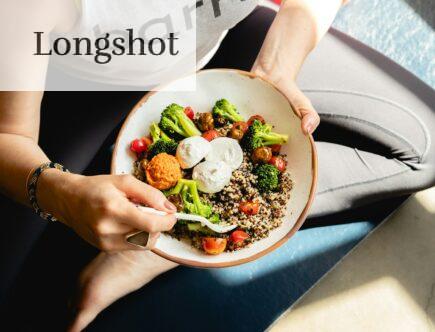 a woman is holding a bowl of food