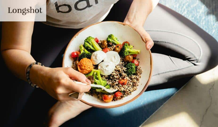 a woman is holding a bowl of food