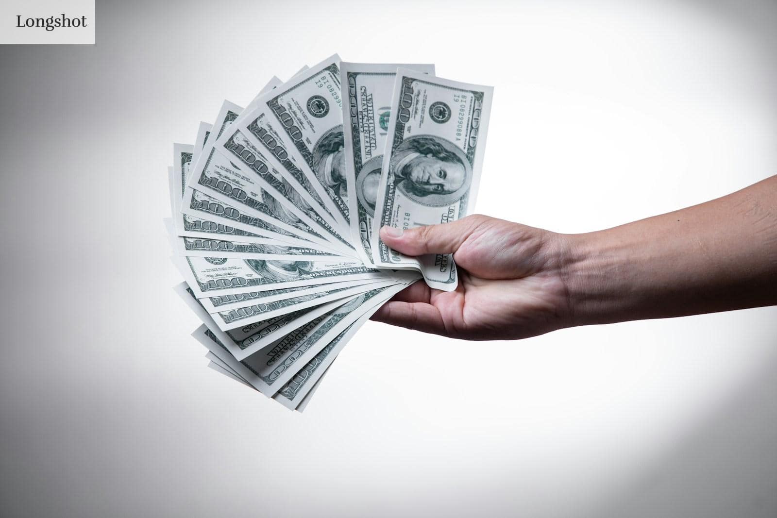 person holding 100 US Dollar banknote