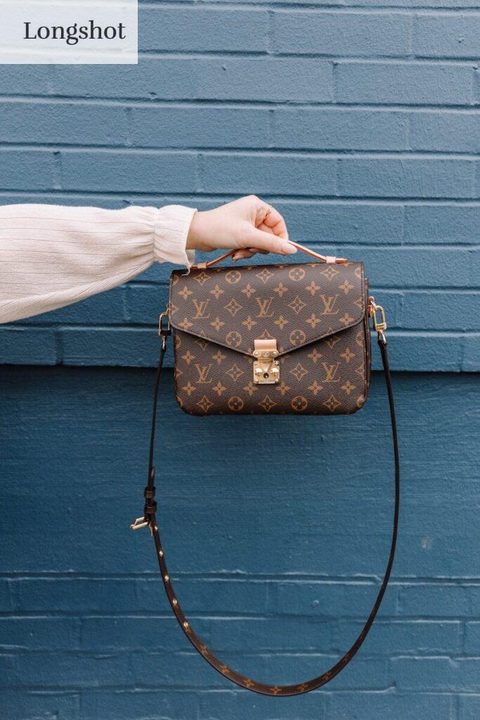 person holding brown leather sling bag